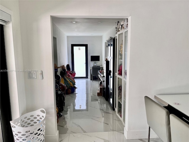 corridor with marble finish floor and baseboards