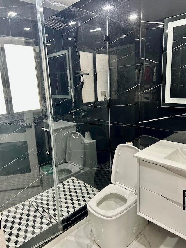 bathroom featuring toilet, vanity, tile walls, marble finish floor, and a stall shower