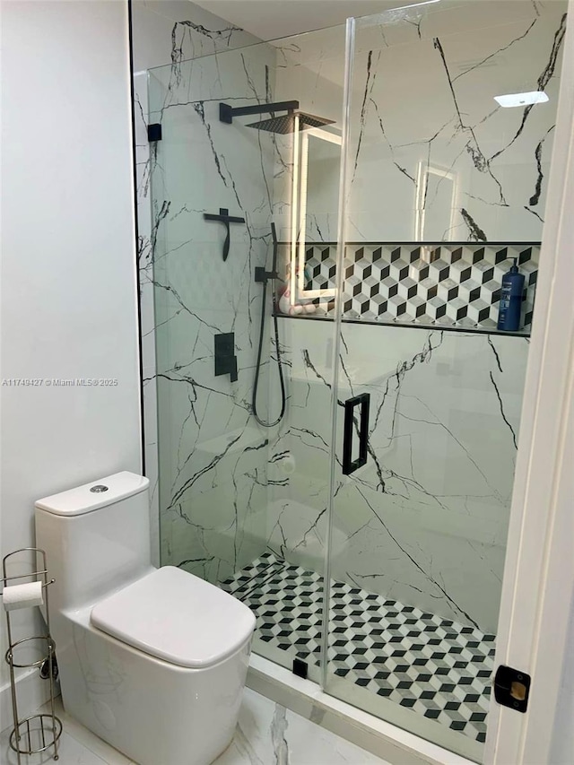 bathroom with a marble finish shower, marble finish floor, and toilet