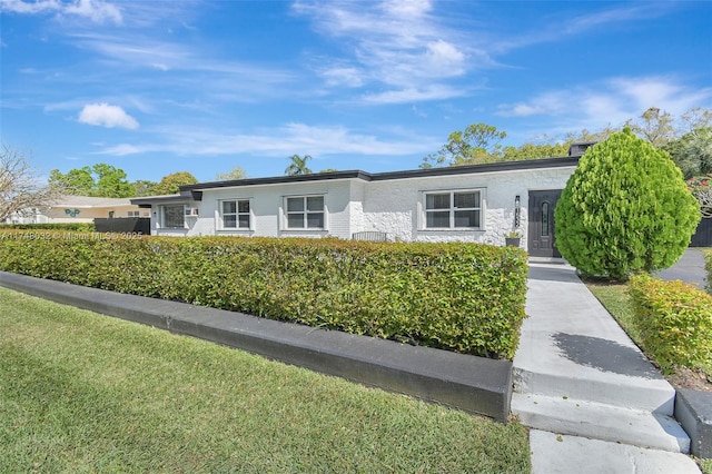 single story home with a front lawn