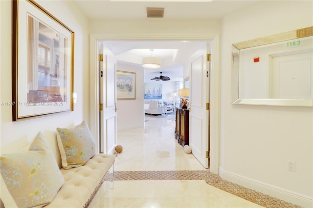 hallway featuring visible vents and baseboards