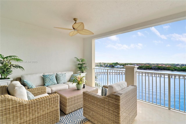 balcony with a water view and a ceiling fan