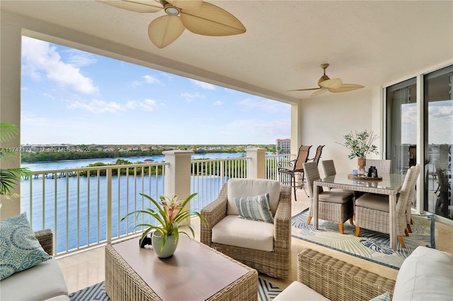 balcony with a water view, an outdoor hangout area, and a ceiling fan