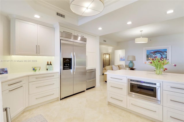 kitchen featuring hanging light fixtures, visible vents, white cabinets, and built in fridge