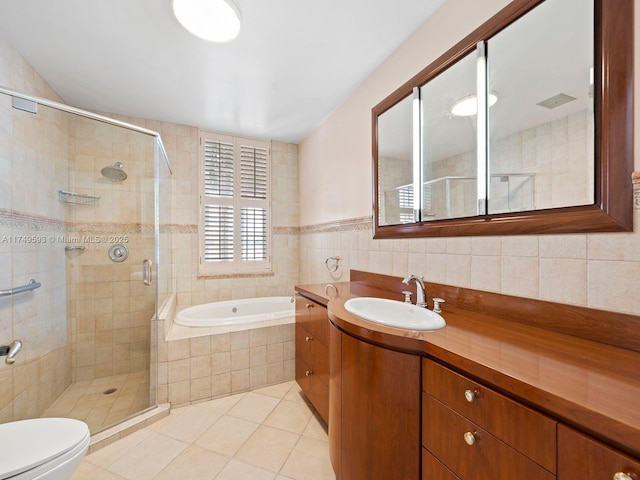 full bathroom featuring a stall shower, tile patterned flooring, vanity, and a bath