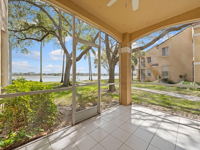 unfurnished sunroom with a water view and a ceiling fan