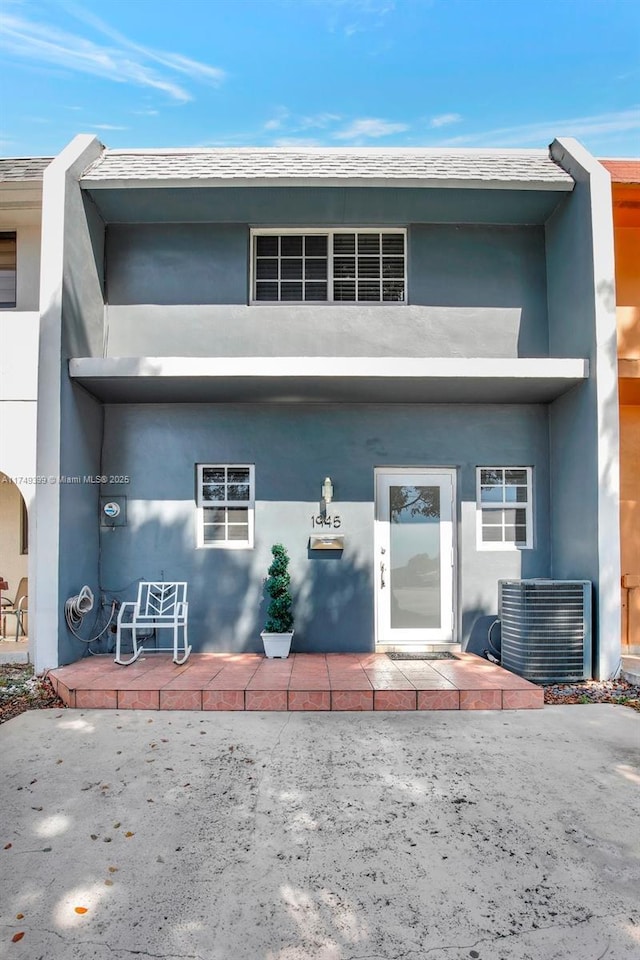 exterior space featuring a patio, cooling unit, and stucco siding