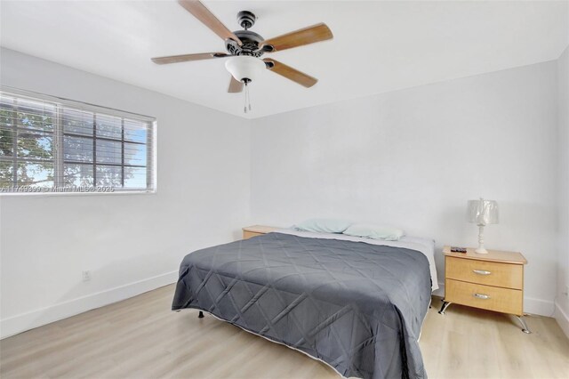 bedroom featuring baseboards, ceiling fan, and light wood-style floors