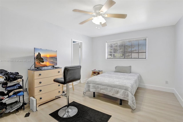 bedroom featuring light wood-style floors, ceiling fan, and baseboards