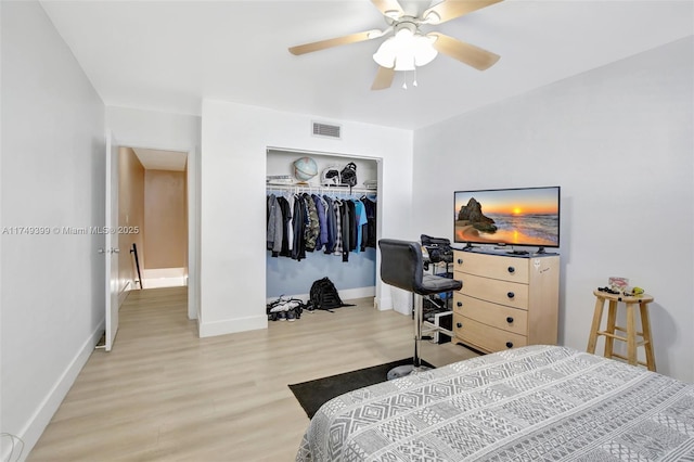 bedroom featuring a closet, visible vents, a ceiling fan, wood finished floors, and baseboards