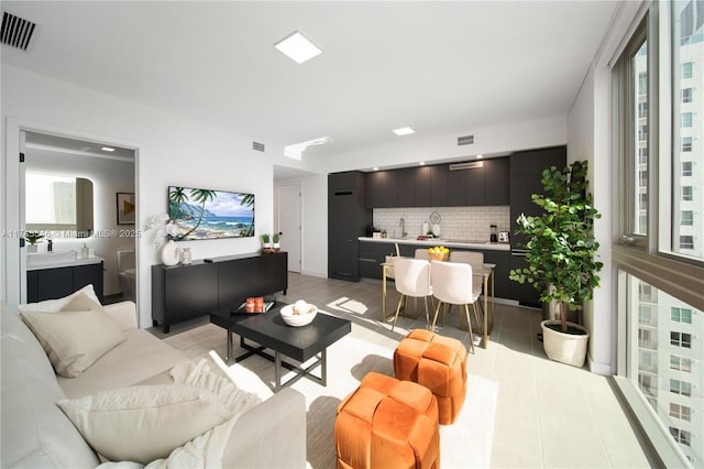 living area featuring light tile patterned flooring and visible vents