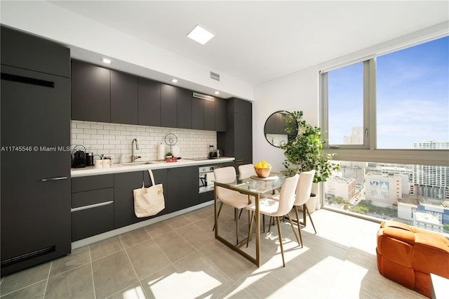 kitchen featuring light countertops, modern cabinets, a sink, and dark cabinets