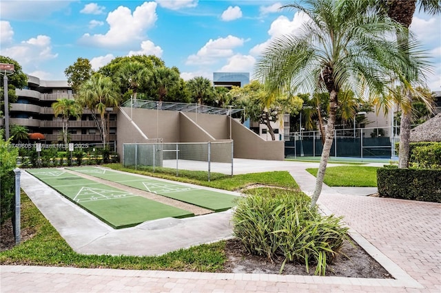 view of home's community featuring fence and shuffleboard