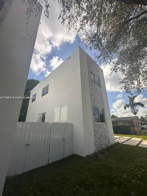 view of home's exterior featuring stucco siding, a yard, and fence