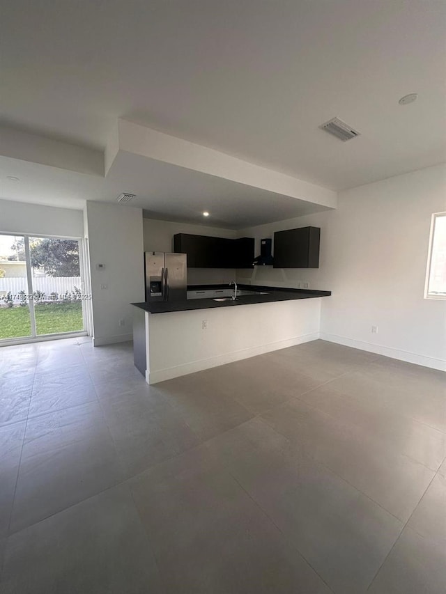 kitchen featuring dark countertops, open floor plan, stainless steel fridge, and visible vents