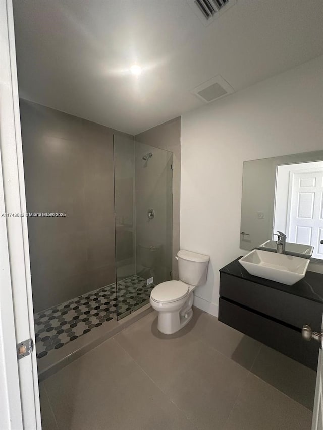 bathroom featuring vanity, visible vents, tile patterned flooring, a shower stall, and toilet