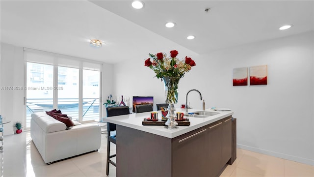 7875 NW 107th Ave Unit 511, Doral, FL 33178 - kitchen with an island with sink, open floor plan, a sink, and light countertops