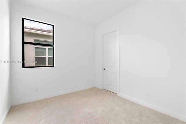 carpeted empty room with baseboards