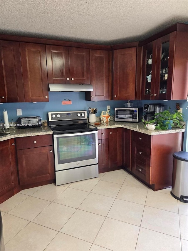 kitchen featuring a toaster, glass insert cabinets, light stone counters, stainless steel electric range, and under cabinet range hood