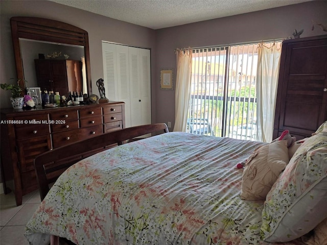 bedroom featuring light tile patterned floors, access to outside, a closet, and a textured ceiling