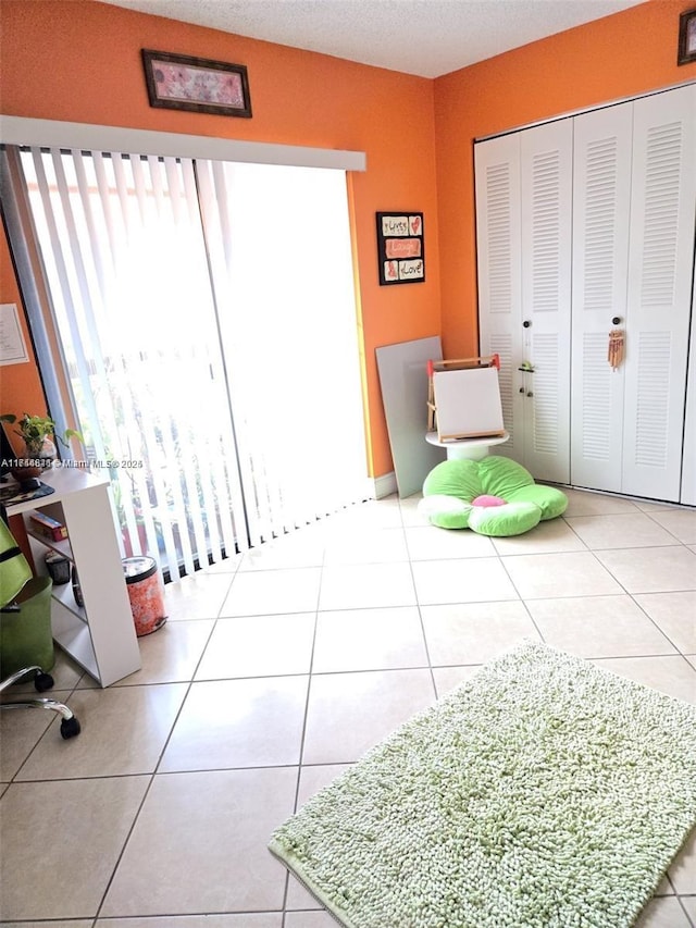 interior space with a textured ceiling and light tile patterned floors