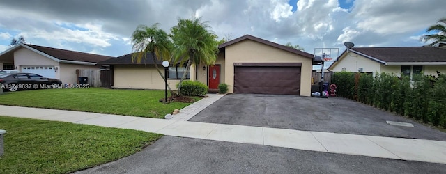 single story home with a garage, aphalt driveway, a front lawn, and stucco siding