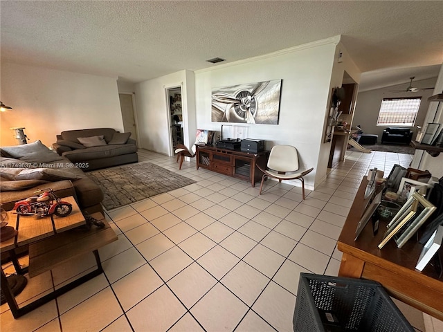 living room with ceiling fan, visible vents, a textured ceiling, and light tile patterned flooring