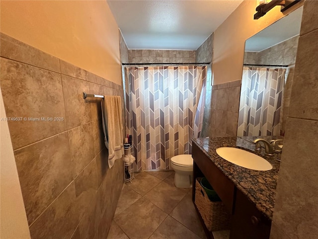 bathroom with a tile shower, tile walls, and tile patterned floors