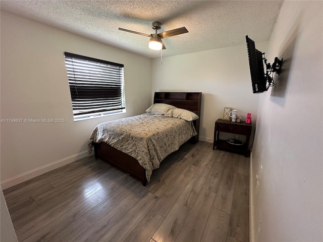 bedroom with a textured ceiling, wood finished floors, a ceiling fan, and baseboards