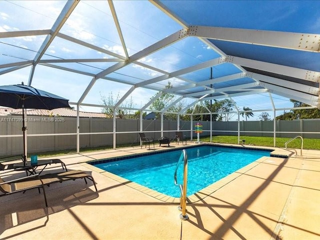 view of pool with glass enclosure, a fenced backyard, a patio area, and a fenced in pool