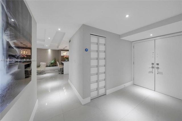 hallway with tile patterned floors, baseboards, and recessed lighting