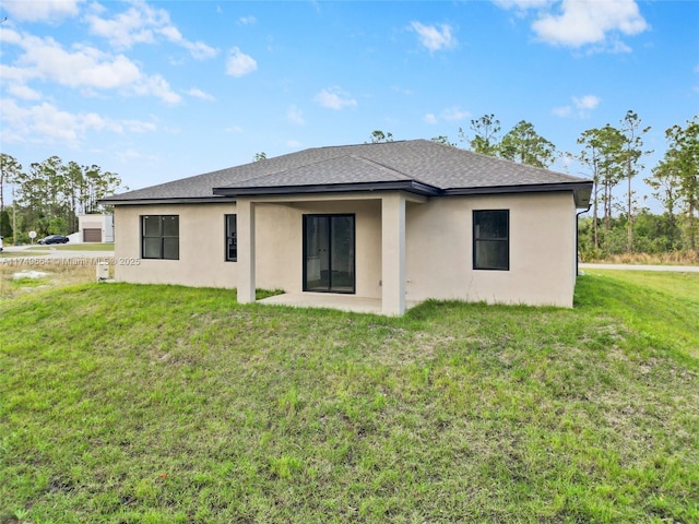 back of house featuring a shingled roof, stucco siding, a patio, and a lawn