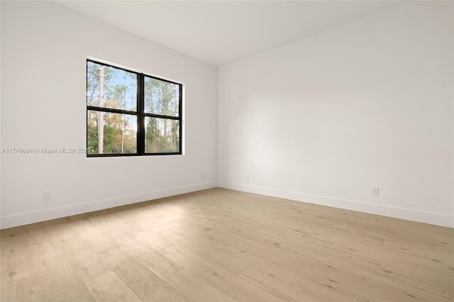 spare room with light wood-style floors and baseboards