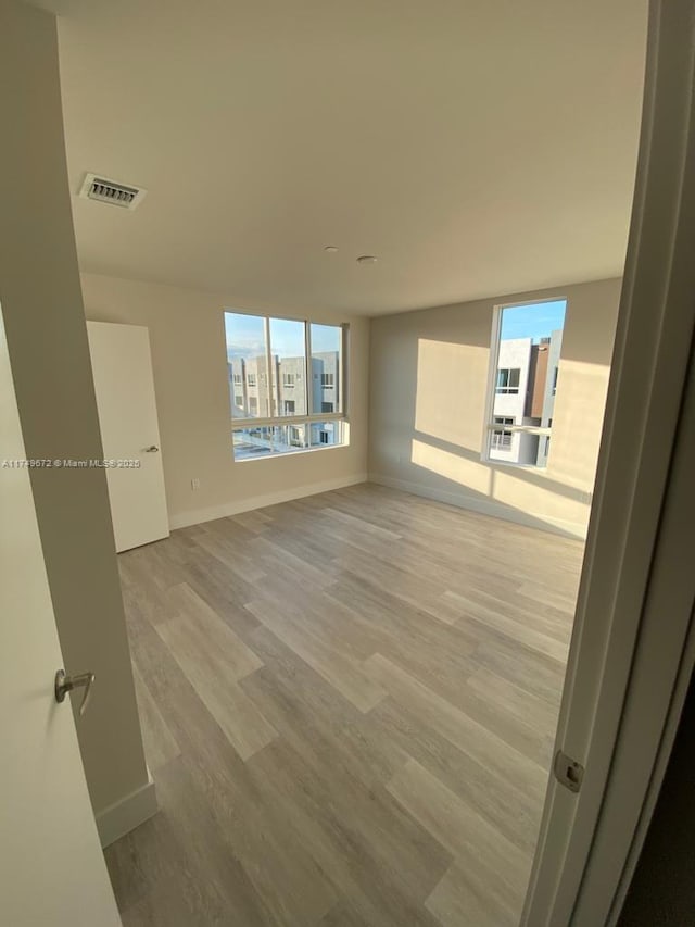 2561 NE 193rd St Unit 1202, Miami, FL 33180 - empty room with baseboards, light wood-style flooring, visible vents, and a wealth of natural light