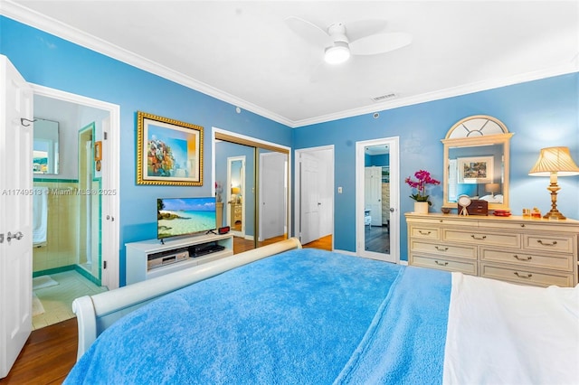 bedroom featuring ornamental molding, ensuite bath, light wood-style flooring, and visible vents