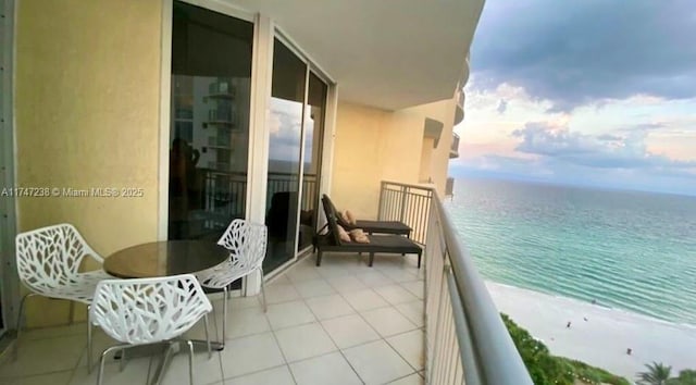 balcony featuring a water view and a beach view