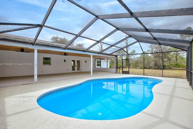 outdoor pool featuring glass enclosure, a patio area, a ceiling fan, and french doors