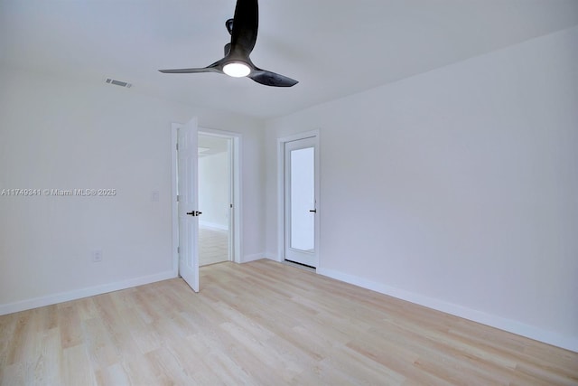 spare room featuring ceiling fan, light wood-type flooring, visible vents, and baseboards