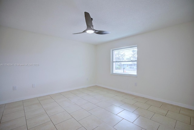 spare room featuring a ceiling fan, a textured ceiling, and baseboards