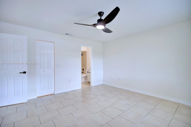 unfurnished bedroom featuring light tile patterned floors, visible vents, a ceiling fan, a textured ceiling, and baseboards