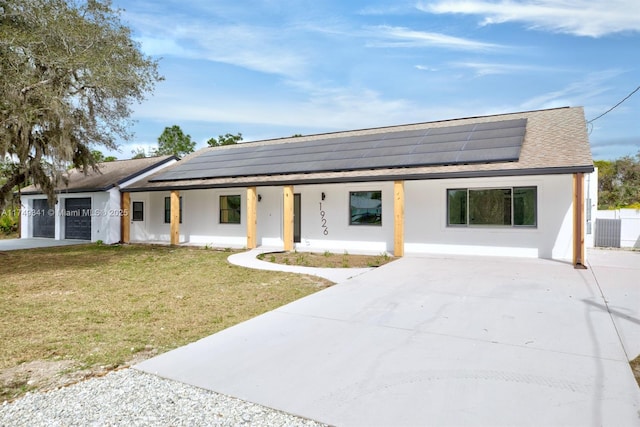 view of front facade with an attached garage, covered porch, roof mounted solar panels, a front lawn, and stucco siding