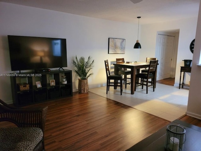 dining area with baseboards and wood finished floors