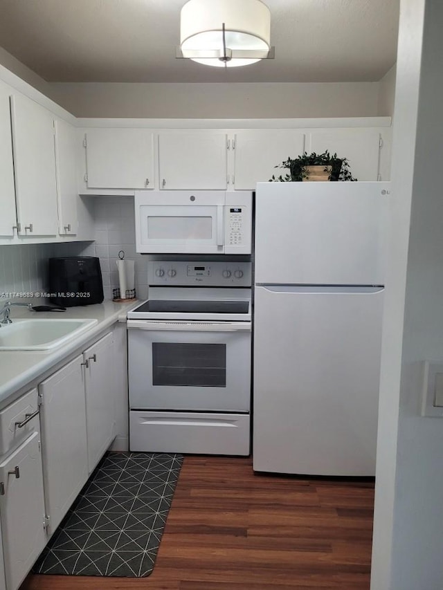 kitchen with white appliances, a sink, white cabinets, light countertops, and decorative backsplash