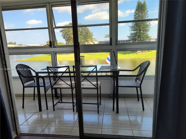 sunroom / solarium featuring a water view