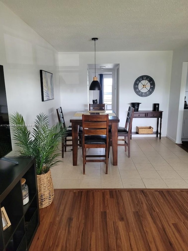 67 Berkshire Unit 67-C, West Palm Beach, FL 33417 - dining area featuring a textured ceiling, light wood-style flooring, and baseboards