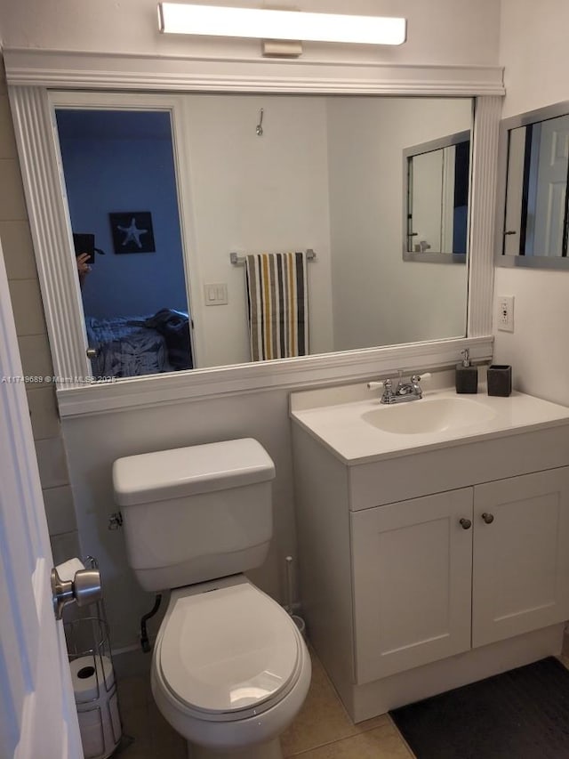 bathroom with tile patterned flooring, vanity, and toilet