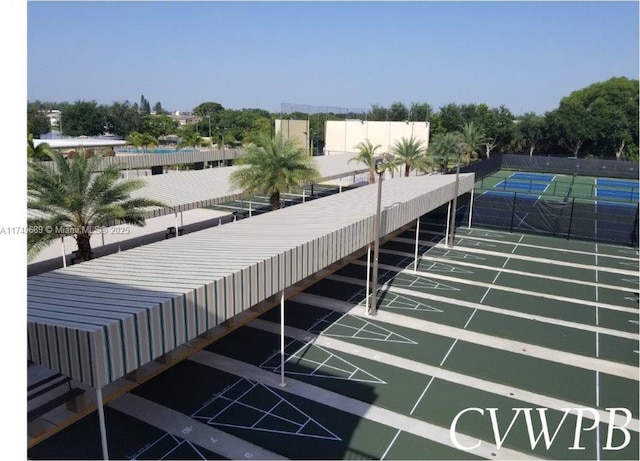 view of home's community with a tennis court, fence, and shuffleboard