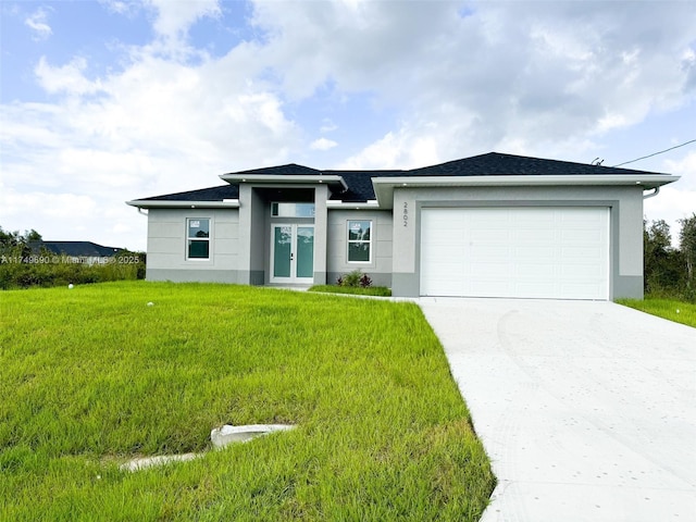 prairie-style house featuring an attached garage, driveway, a front lawn, and stucco siding