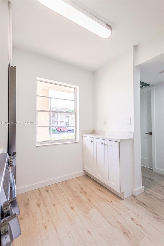 empty room featuring light wood finished floors and baseboards