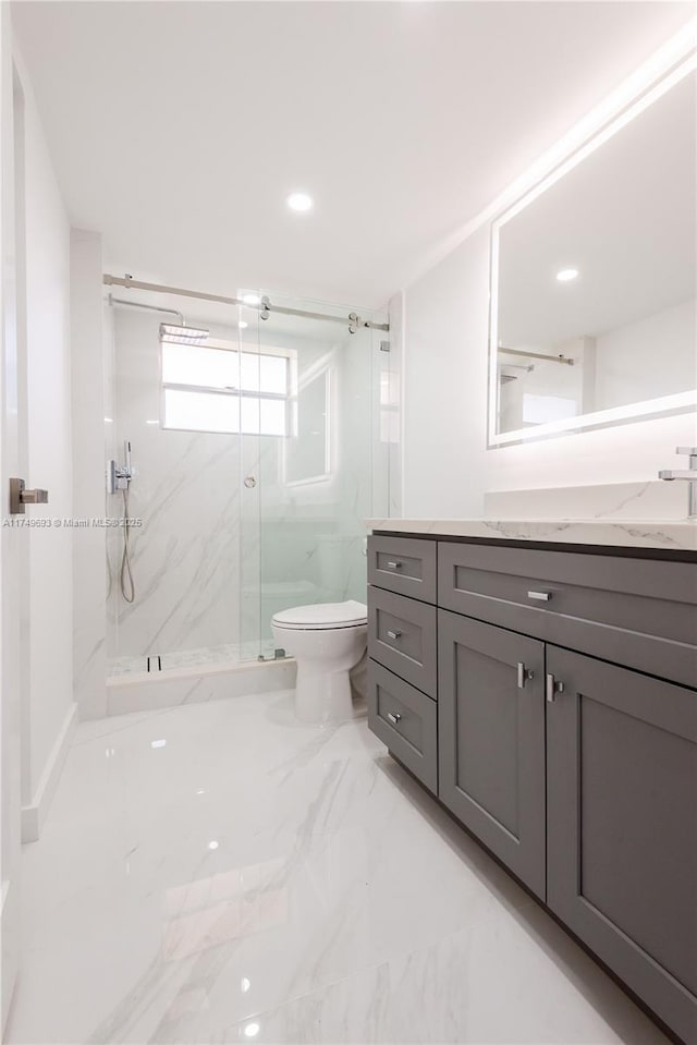 bathroom featuring marble finish floor, a marble finish shower, recessed lighting, toilet, and vanity